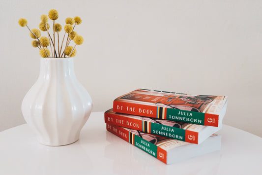 by the book Julia sonneborn book stacks with vase