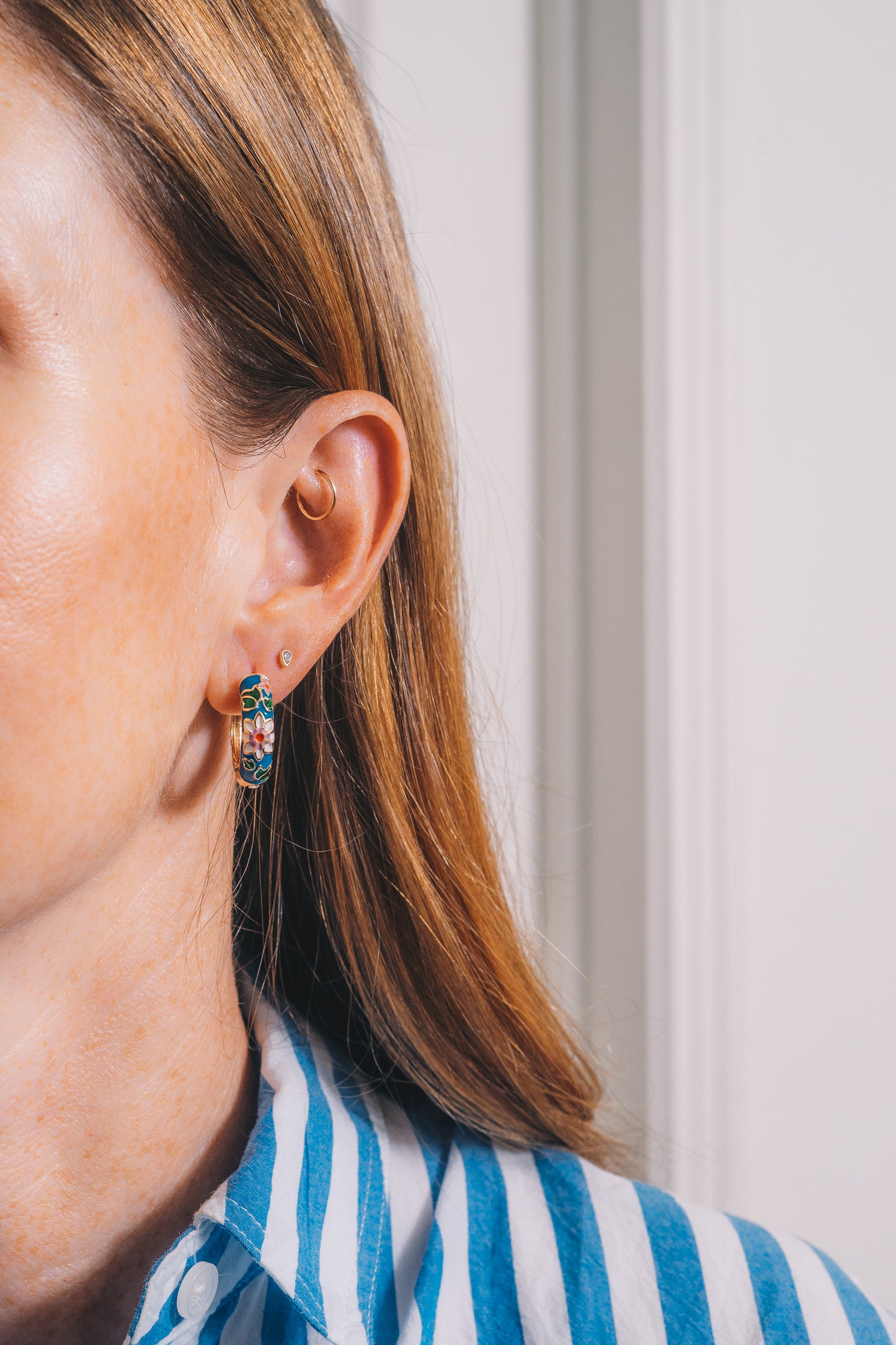 blue flower enamel huggie hoop earrings on model