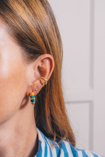 multi colored enamel Huggie hoops with multi strand crystal and gold ear cuff earring on model side view