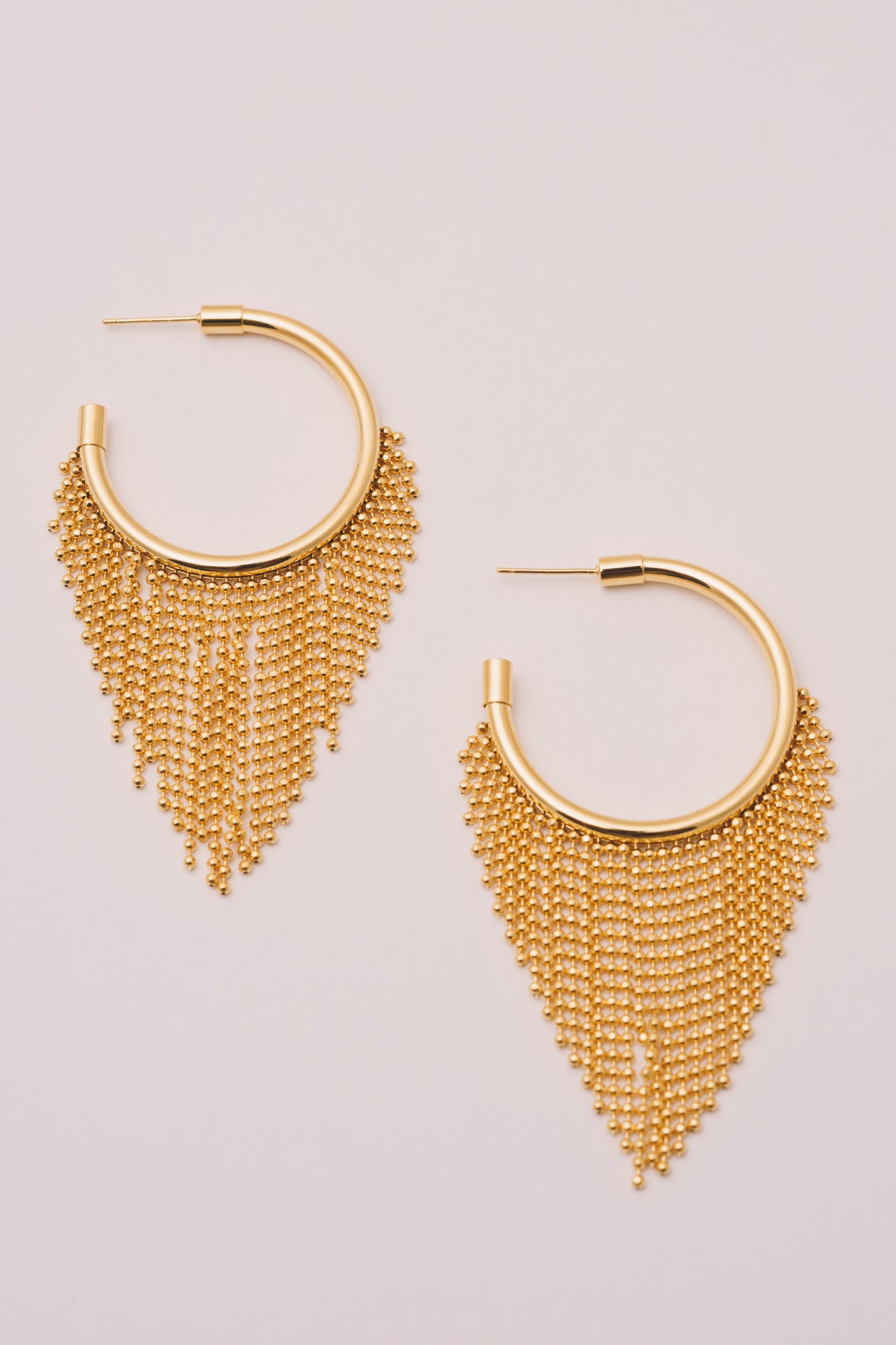 gold ball chain fringe hoops on white background