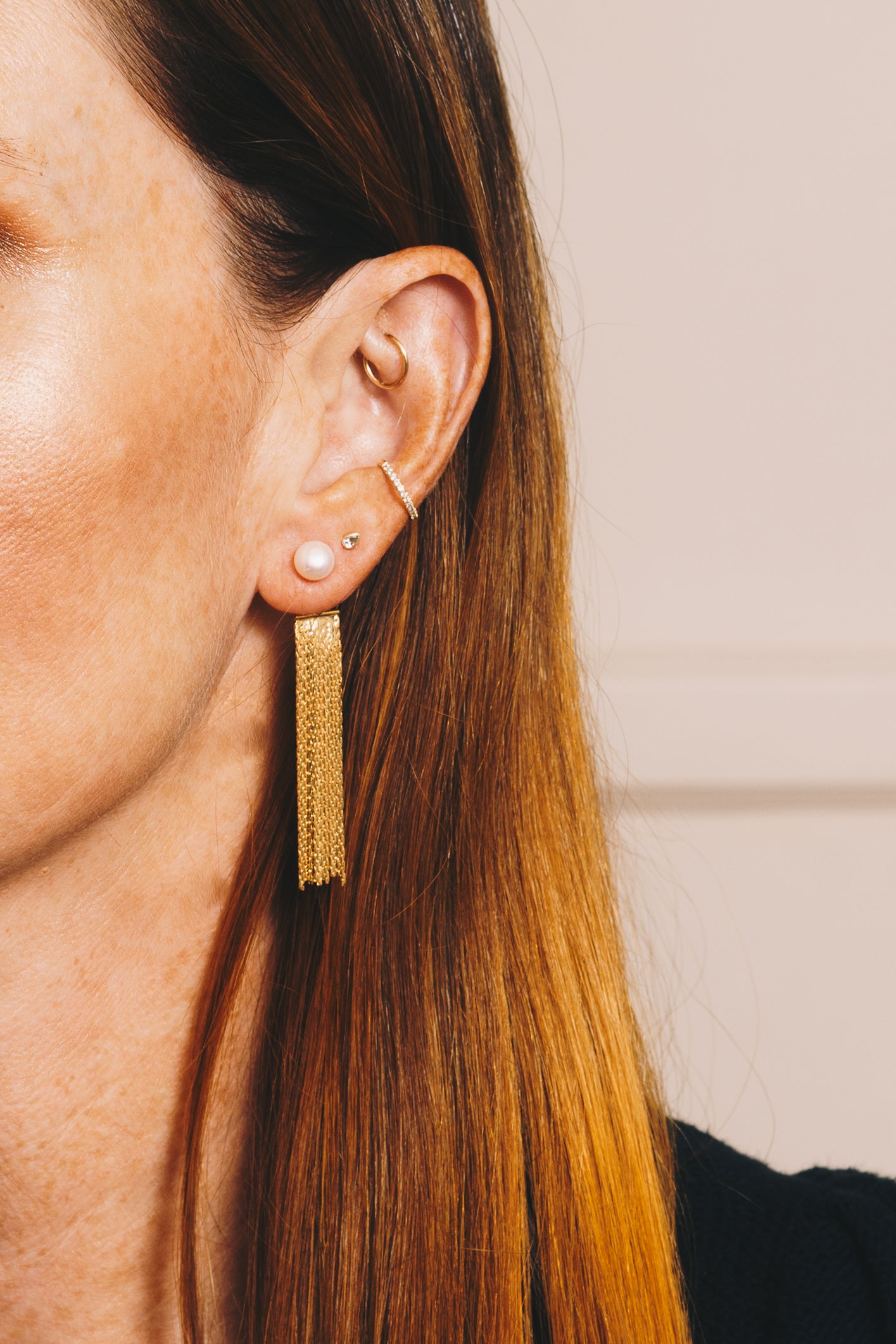 pearl and gold chain tassel ear jackets on red haired model with multiple ear piercings