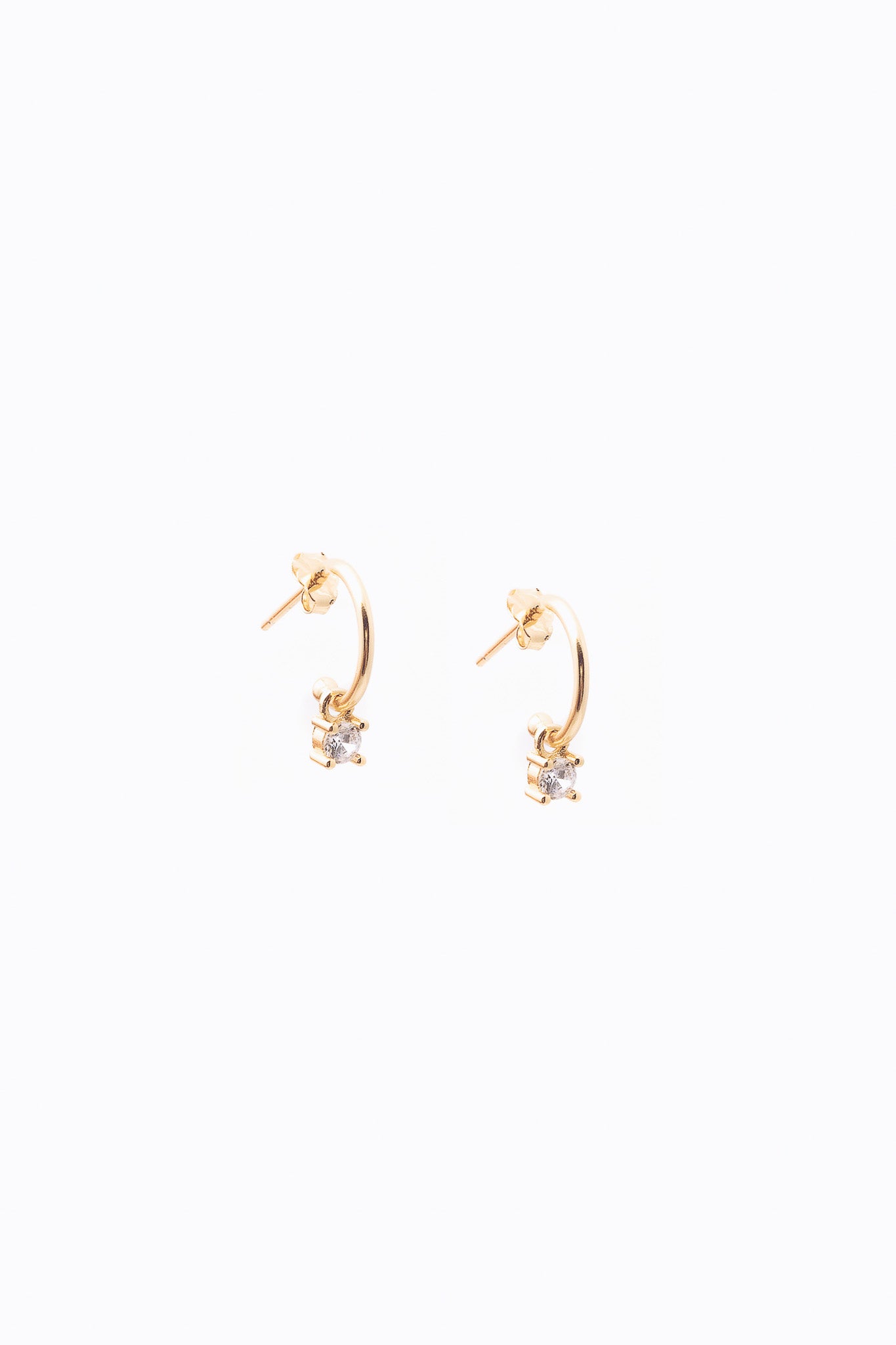 small gold crystal dangle hoops on white background 