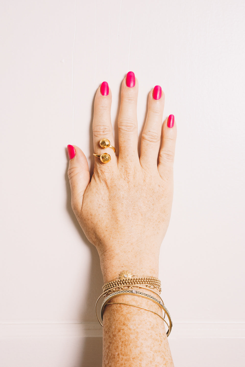 gold disco ball wraparound ring and gold stacking rings on hand