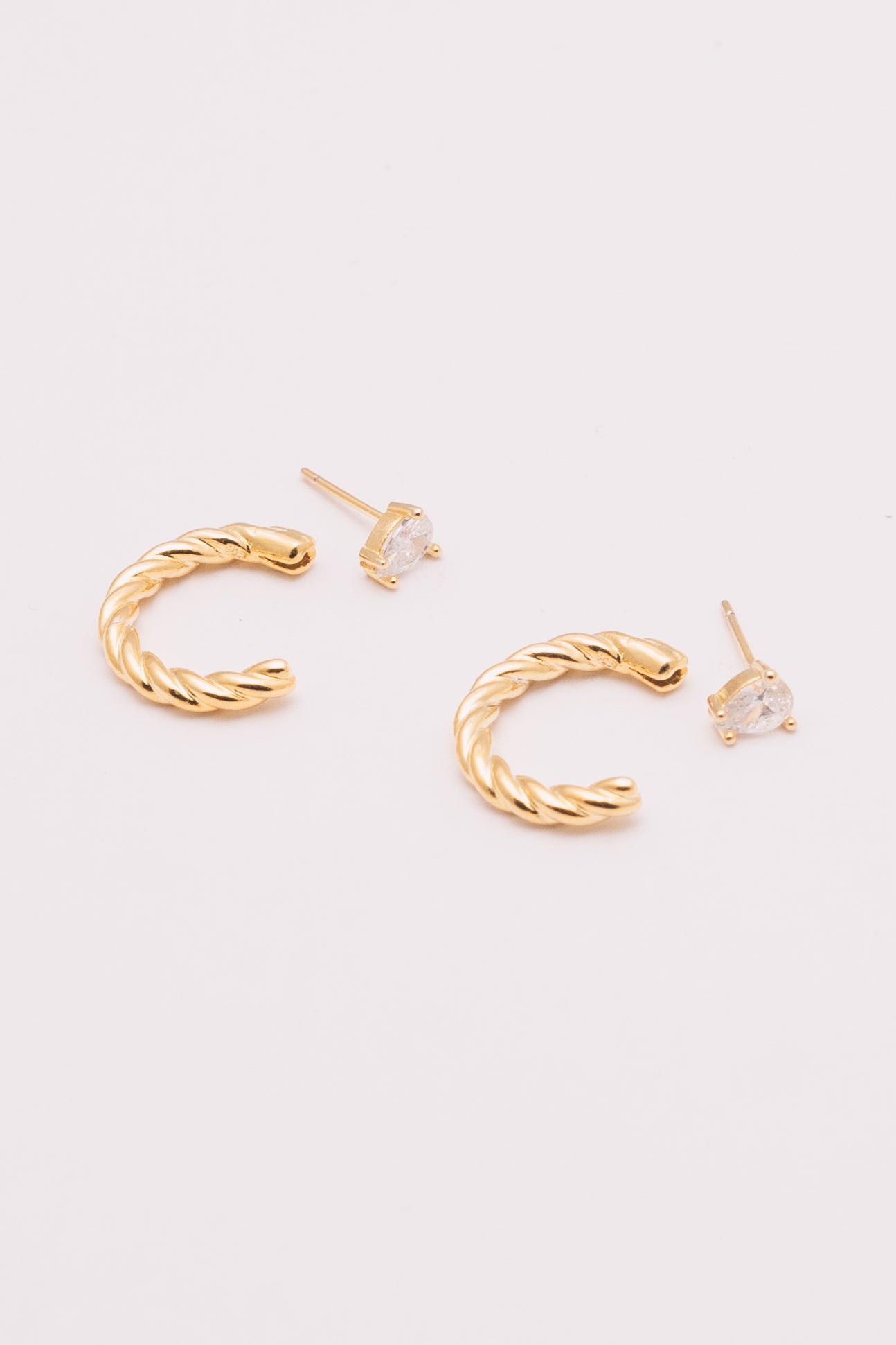 gold ear jacket hoops with crystal pear studs next to them