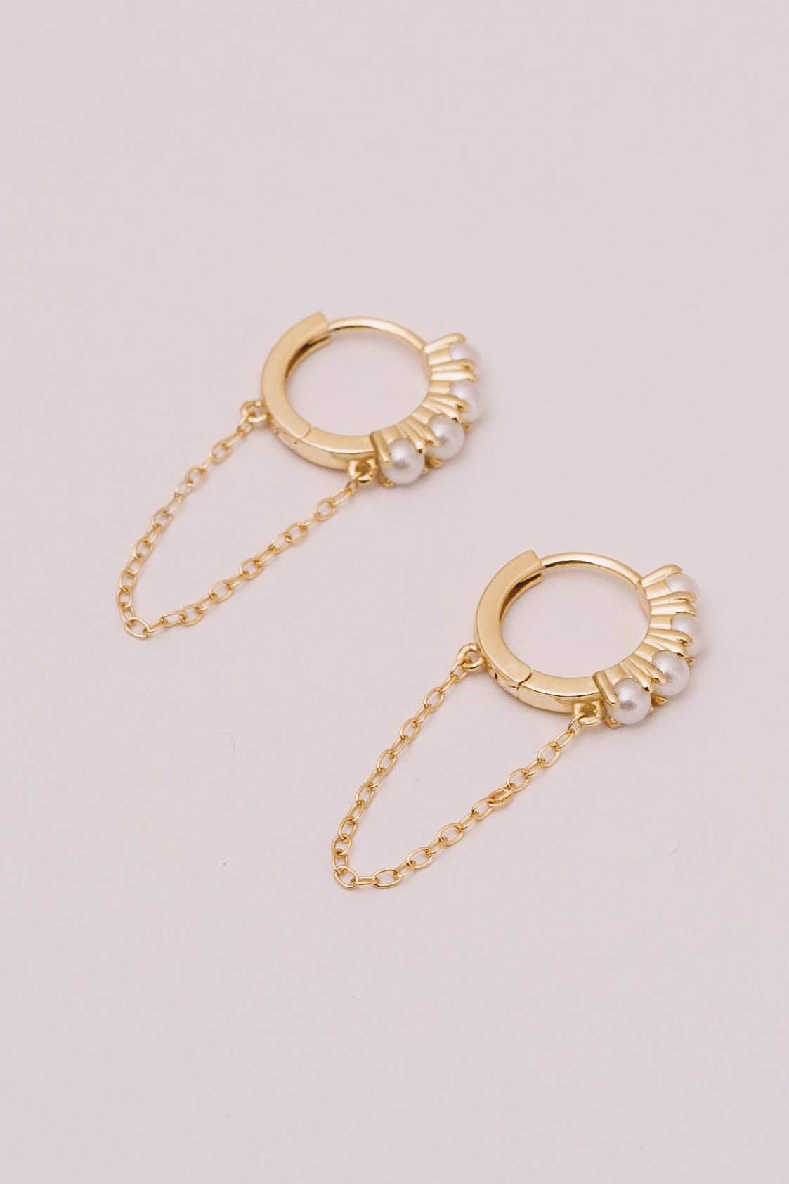 pearl huggie hoops with chain dangles closeup