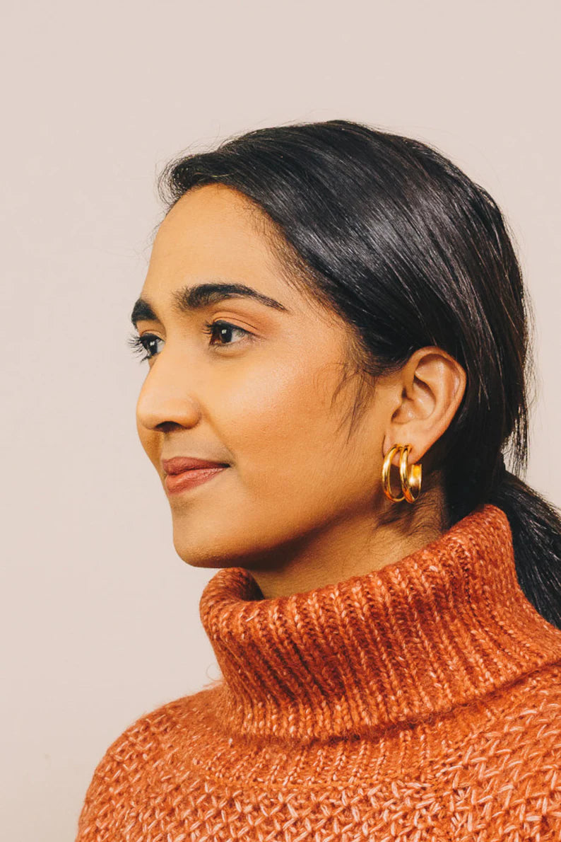 model with gold split hoop earrings in orange turtleneck