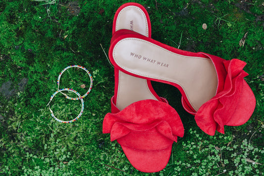 rainbow hoop earrings by janna Conner on moss bed next to red ruffle shoes by who what wear