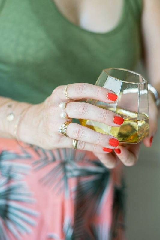 janna Conner holding white wine glass pearl rings red manicure