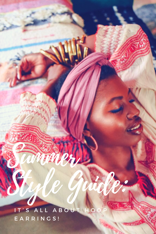 summer style guide Paola Mathé with headwrap and bangle bracelets and hoop earrings summer style guide against patterned bedspread 
