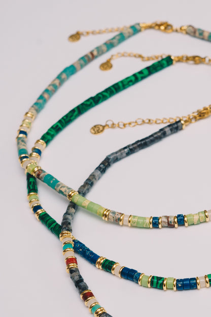 three beaded gemstone necklaces laying next to each other closeup