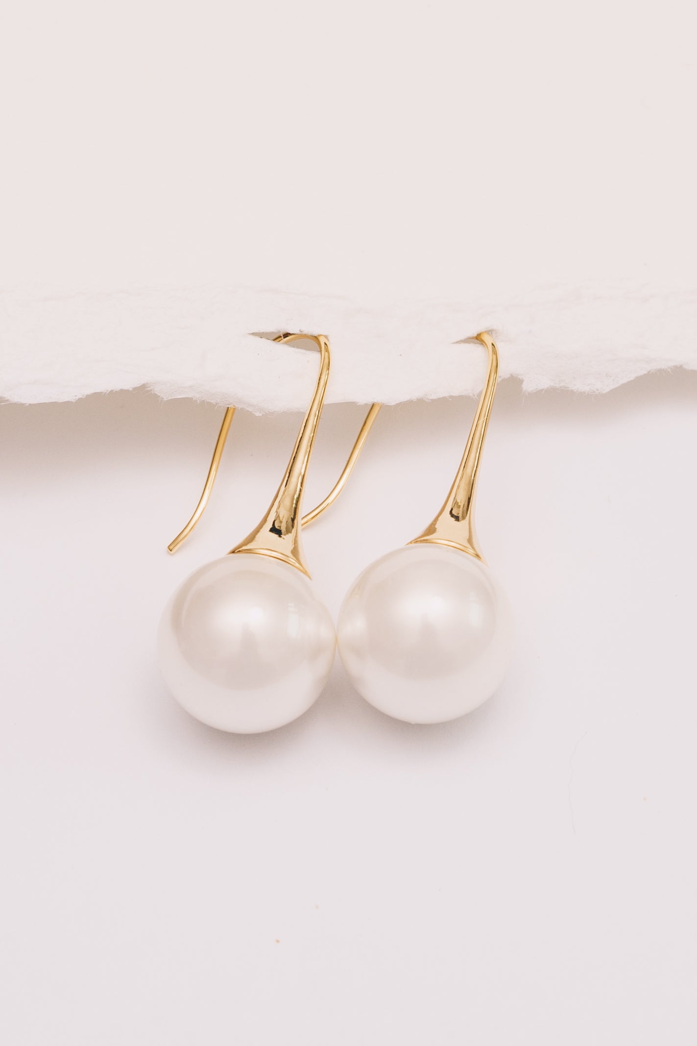 pearl earrings dangle on white background sideview
