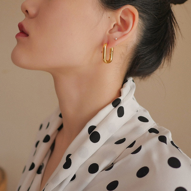 gold rectangular huggie hoop earrings on model