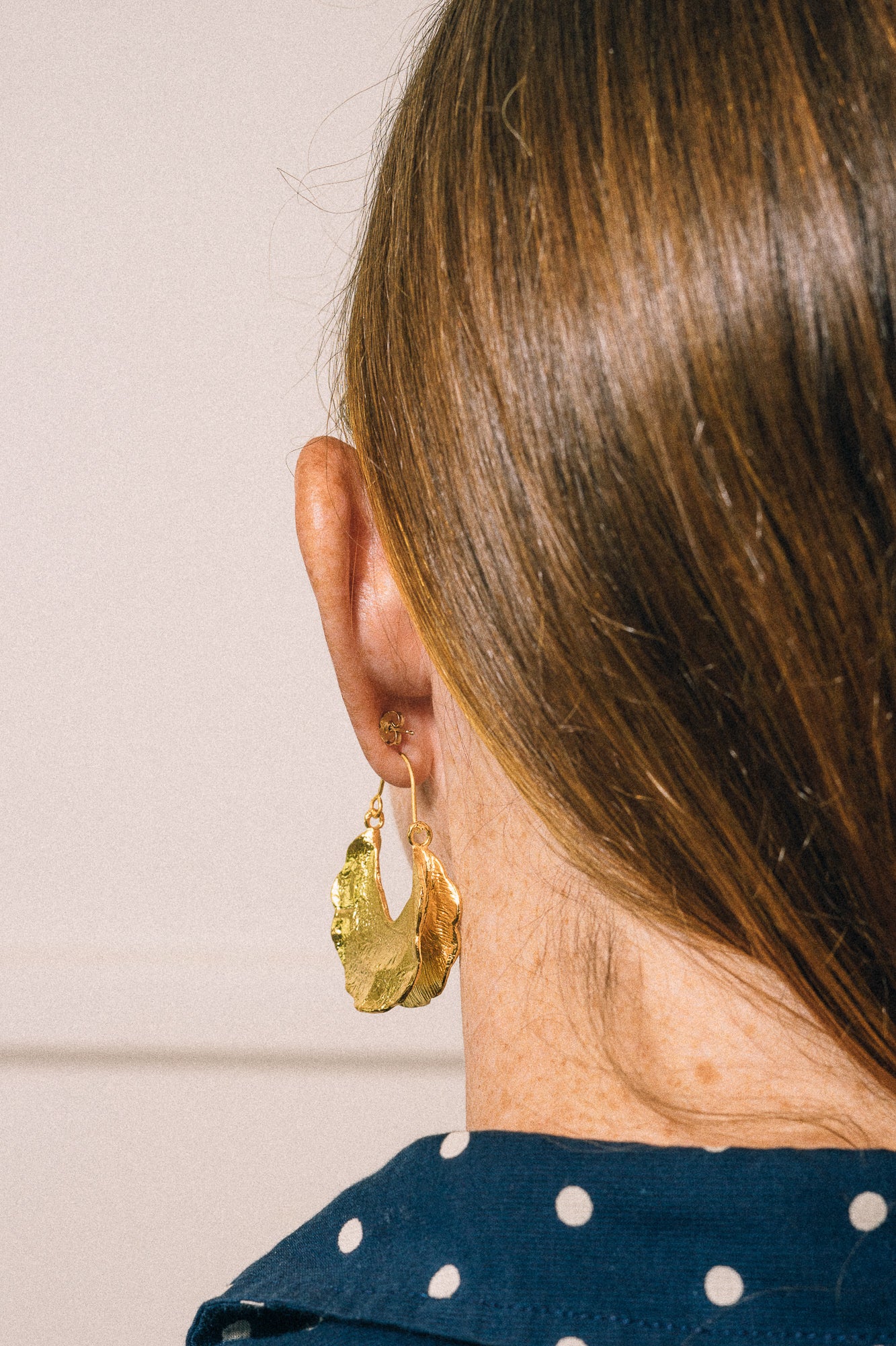 gold hoop earrings on model closeup