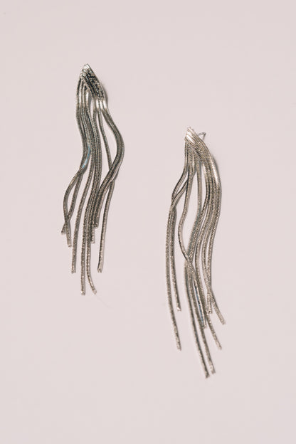silver chain statement earrings on white background