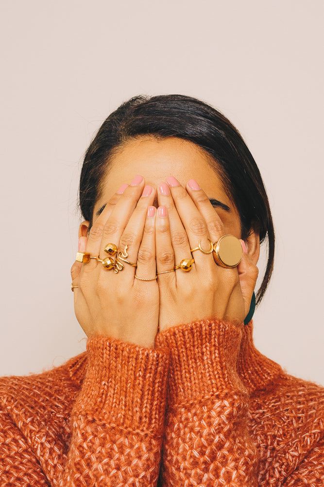 gold stacking rings on model hands in face