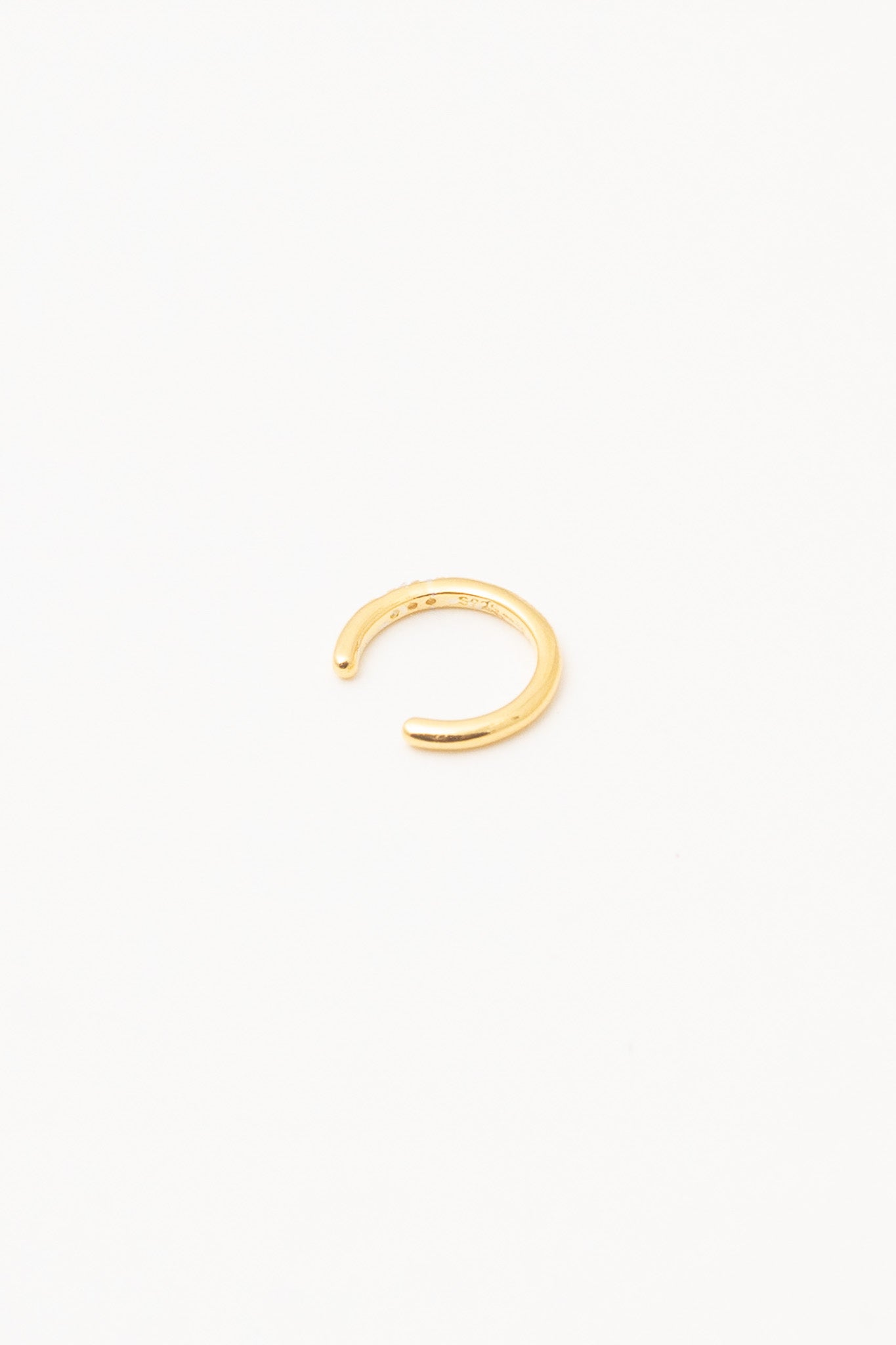 gold ear cuff on white background view from behind