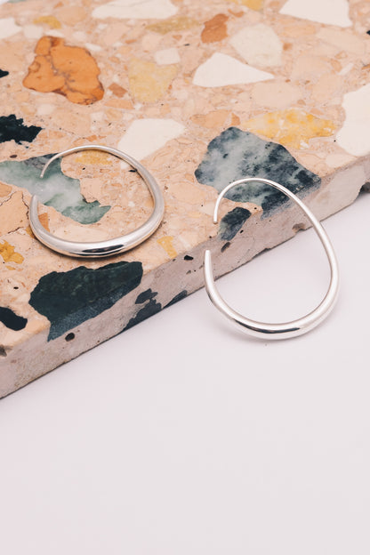 silver threader hoop earrings on patterned marble