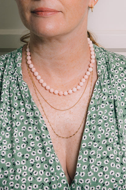 sponge coral beaded necklace layered with other gold chain necklaces