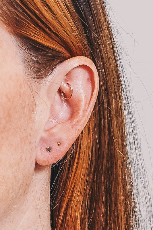 Gold heart earrings with multiple piercings