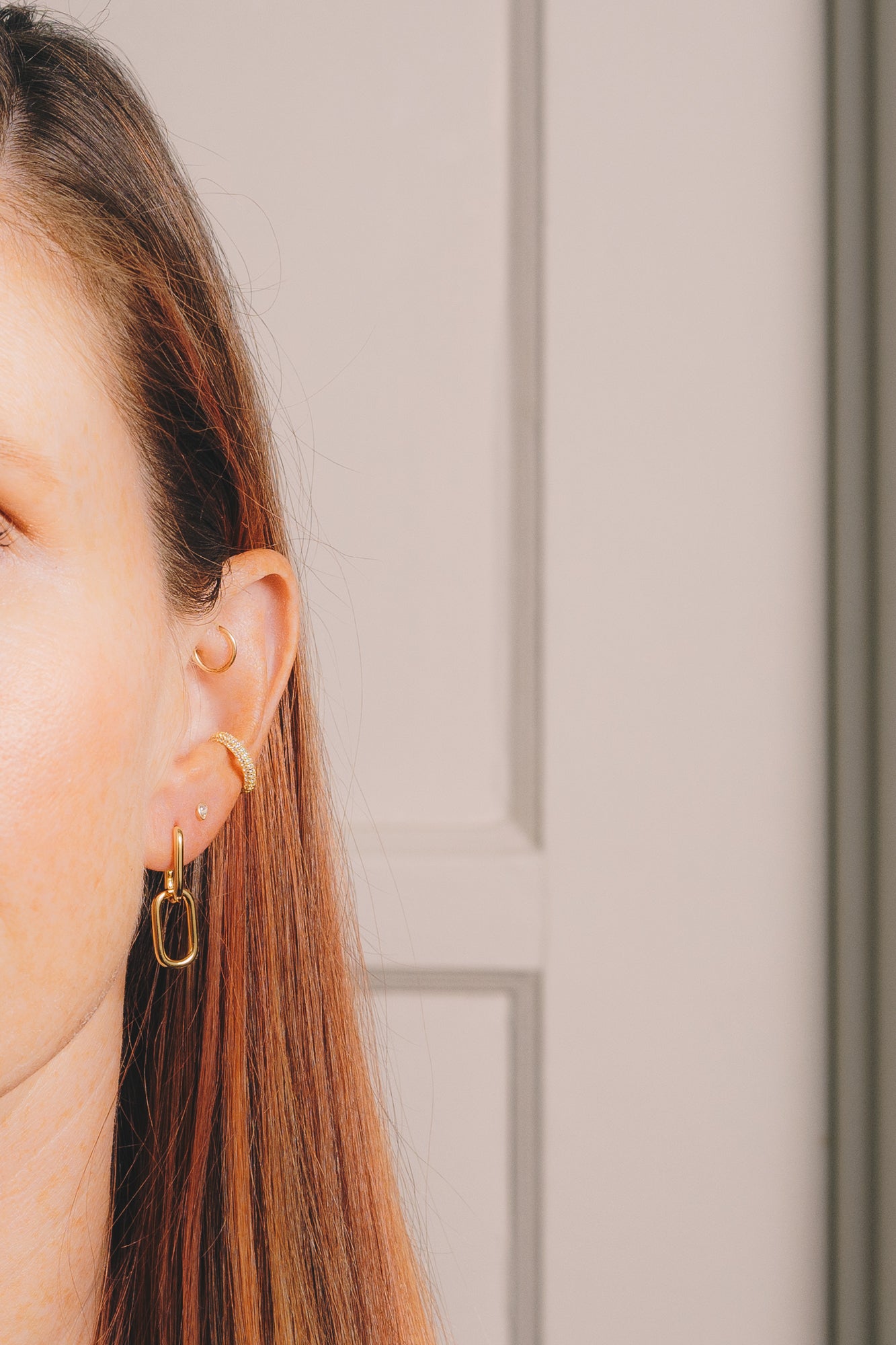 gold huggie hoop drop earrings on model closeup
