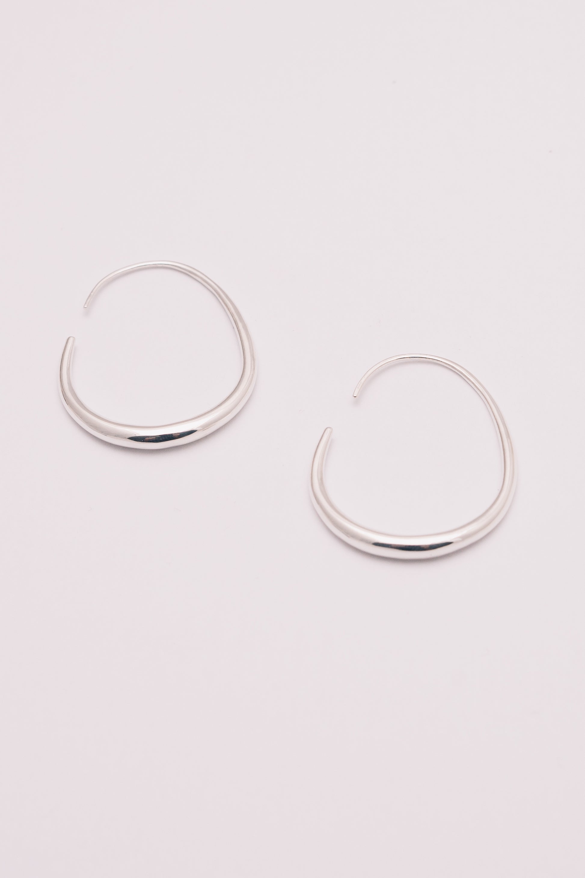 silver threader hoop earrings on white background view from below