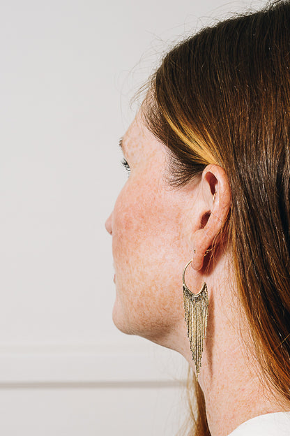 gold chain hoop earrings on model side view