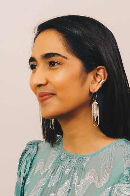 gold ear cuff and dangle earrings on model