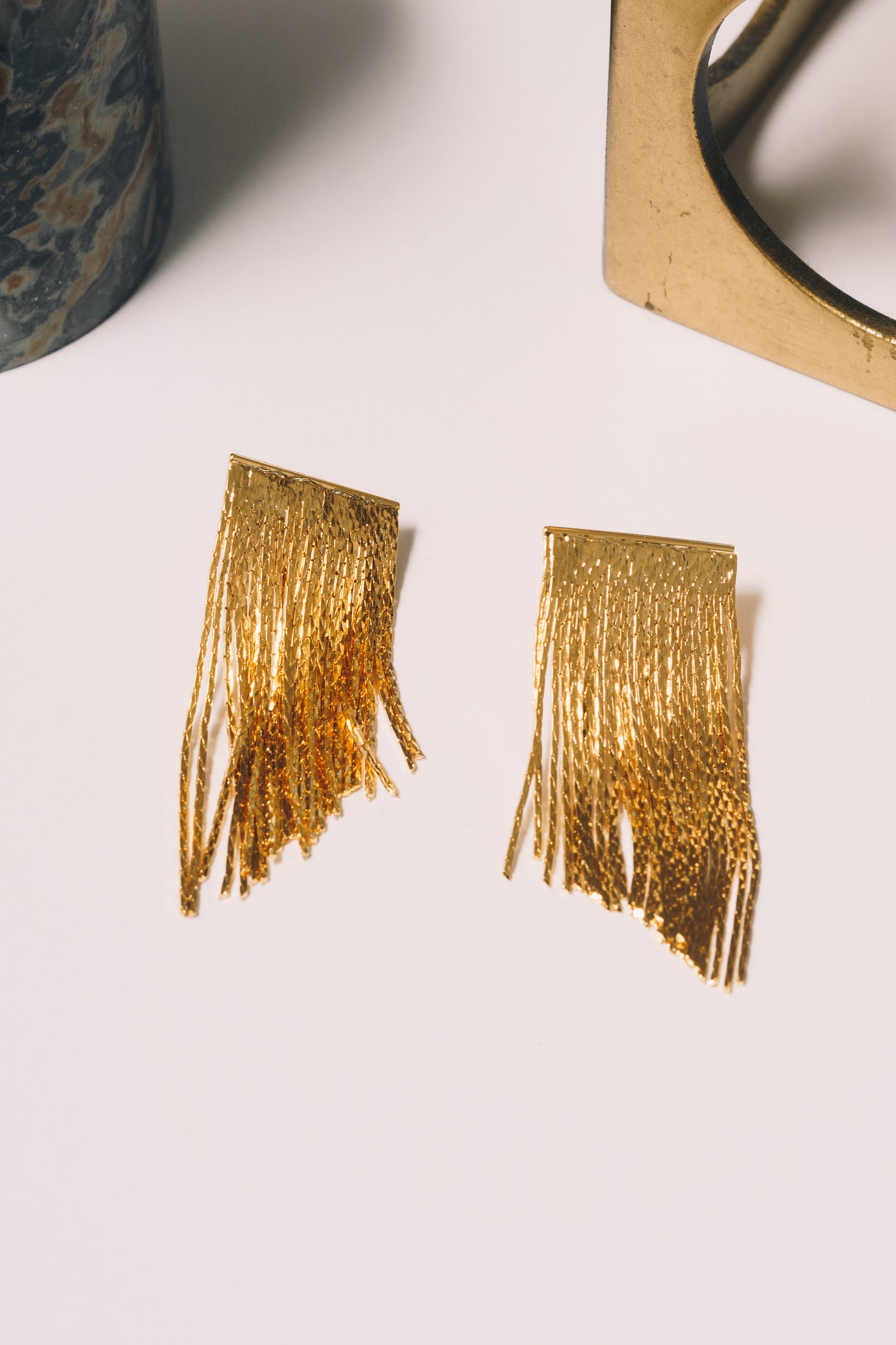 gold fringe stud earrings closeup
