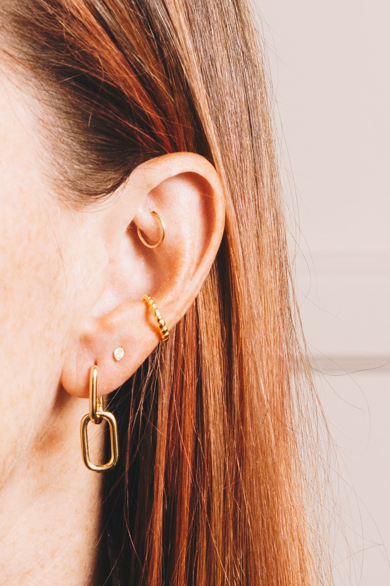 gold huggie hoop drop earrings closeup with earcuff