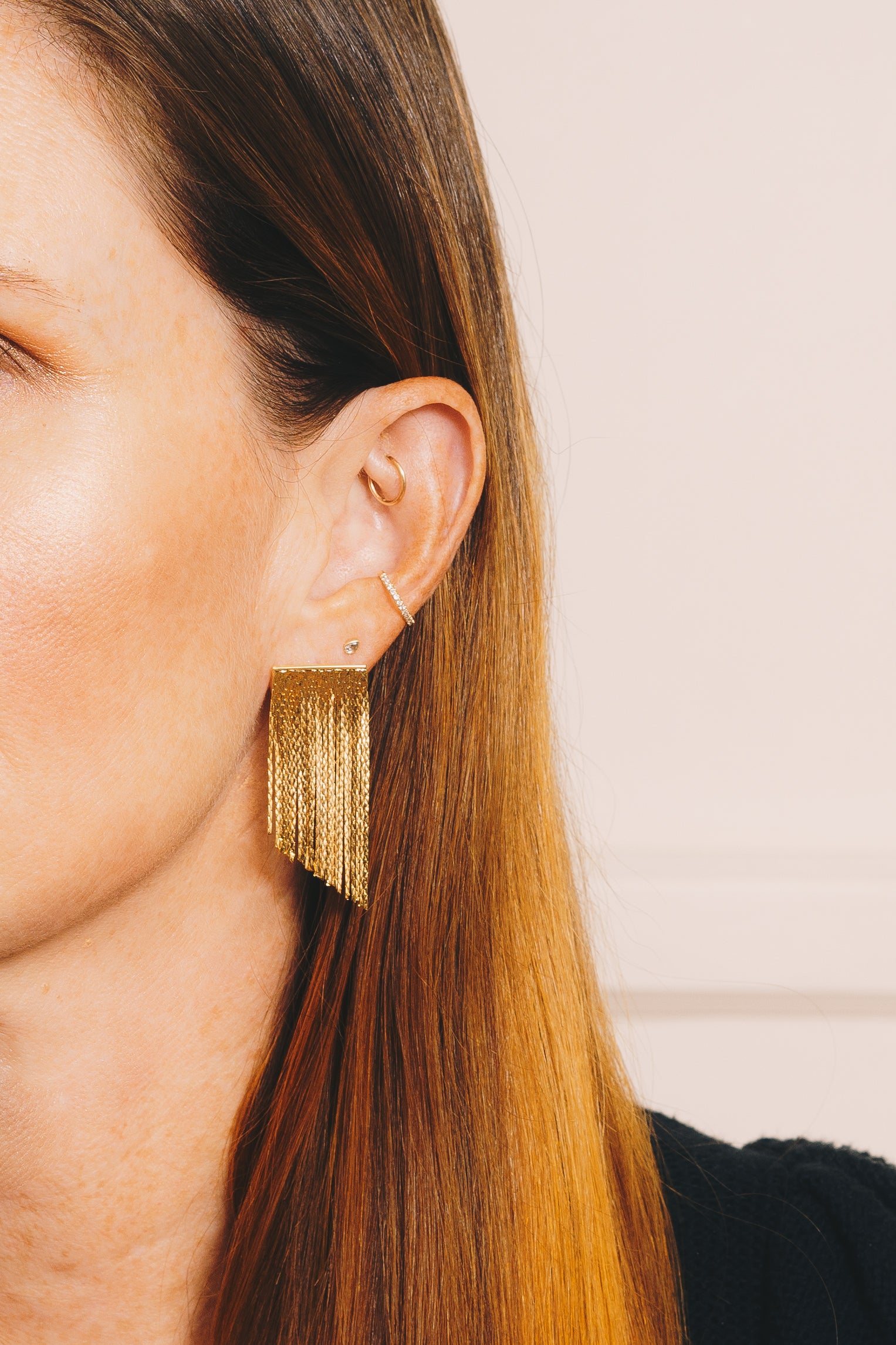 gold fringe waterfall earrings on red haired model with multiple ear piercings