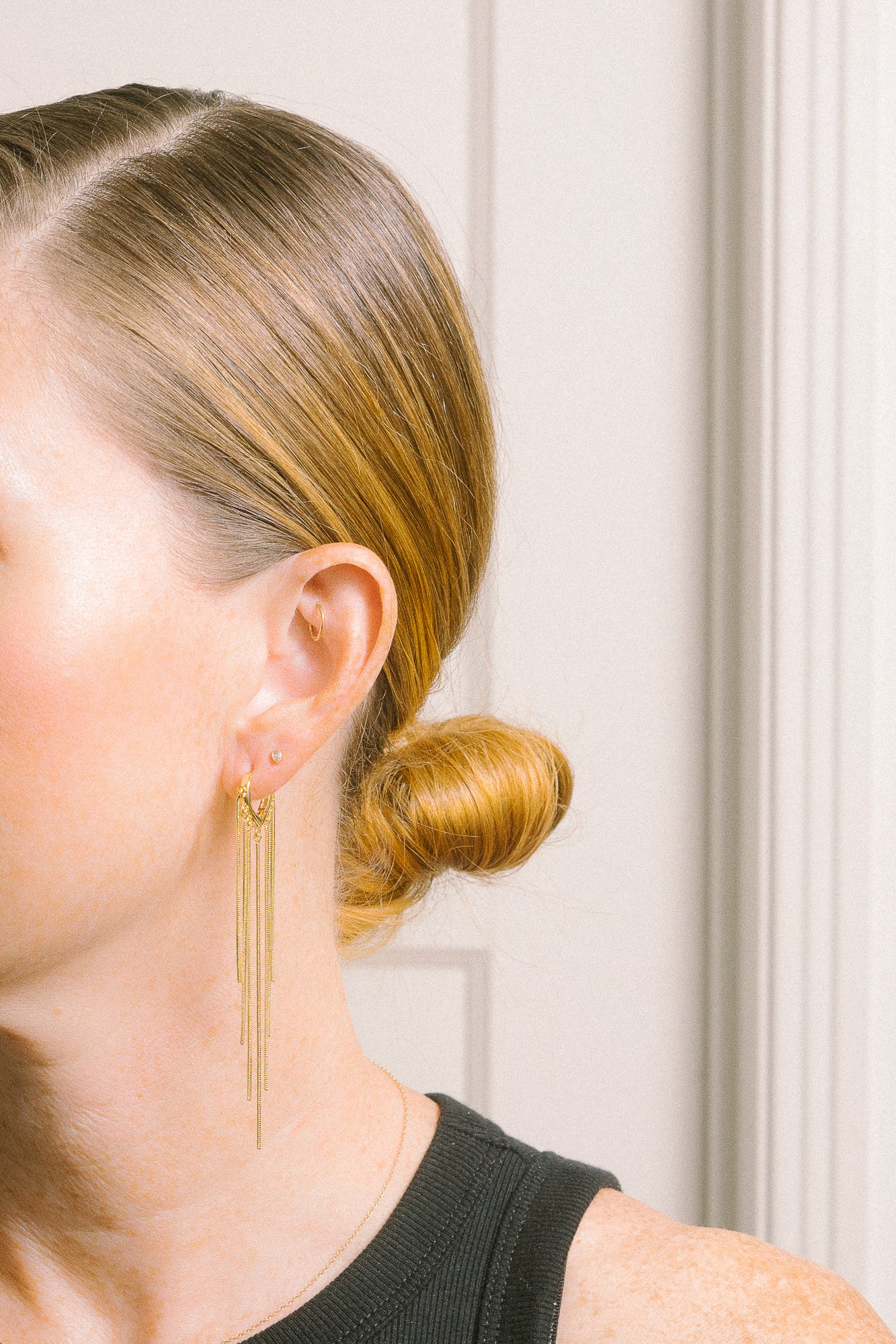 gold chain fringe earrings on model profile