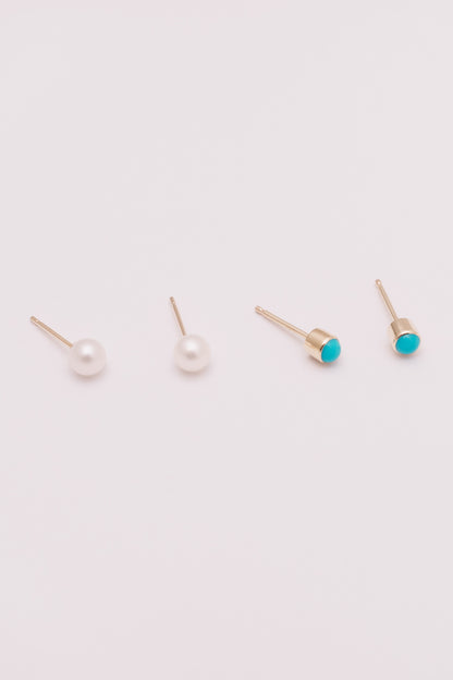 tiny pearl and turquoise stud earrings in gold side by side on white background