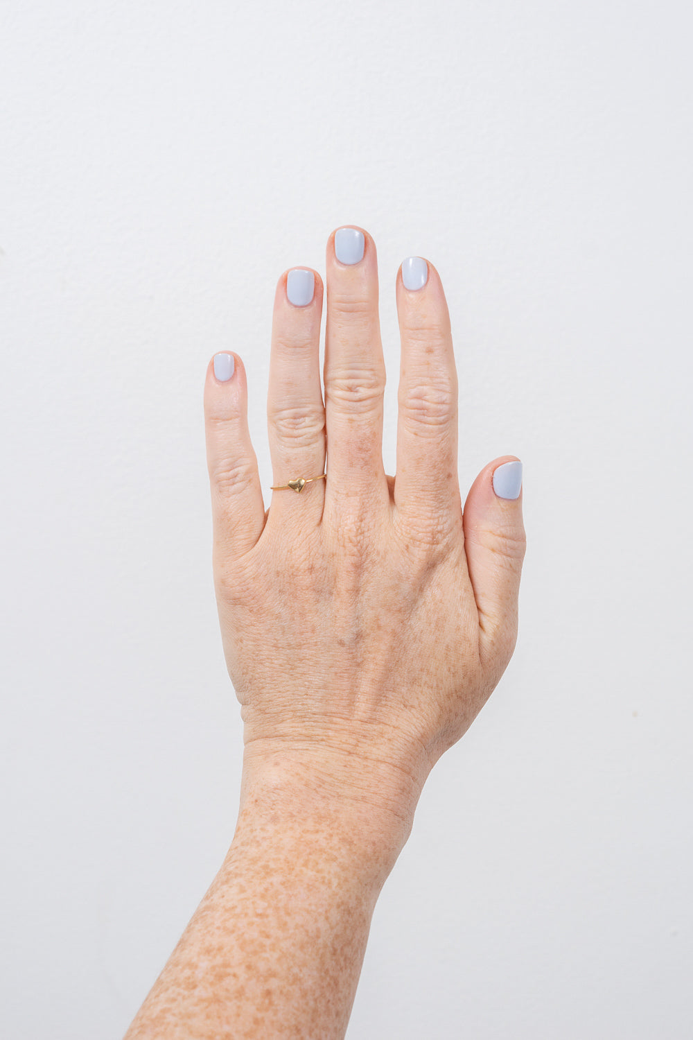 gold heart stacking ring by janna conner on hand model