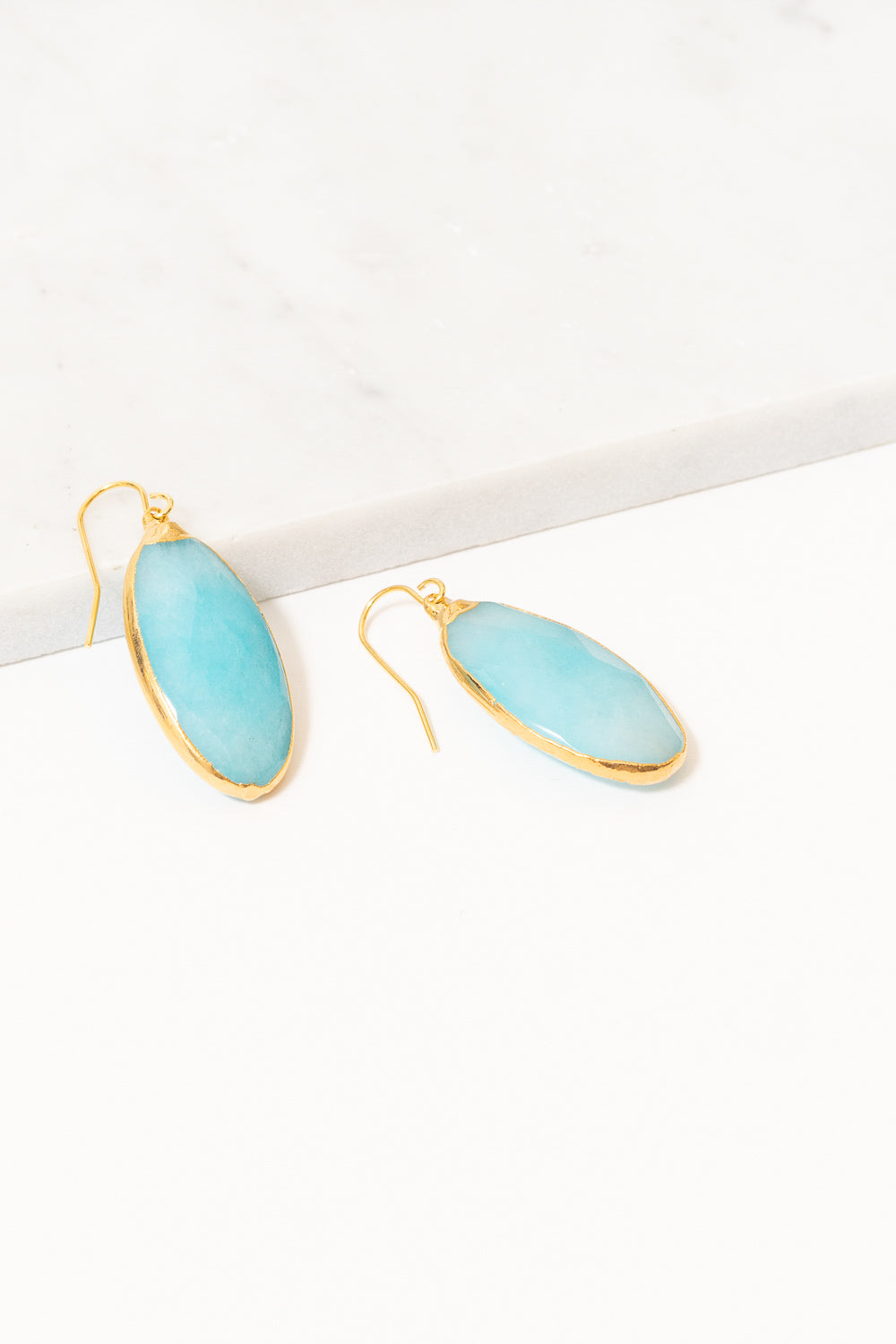 turquoise jade dangle earrings on marble