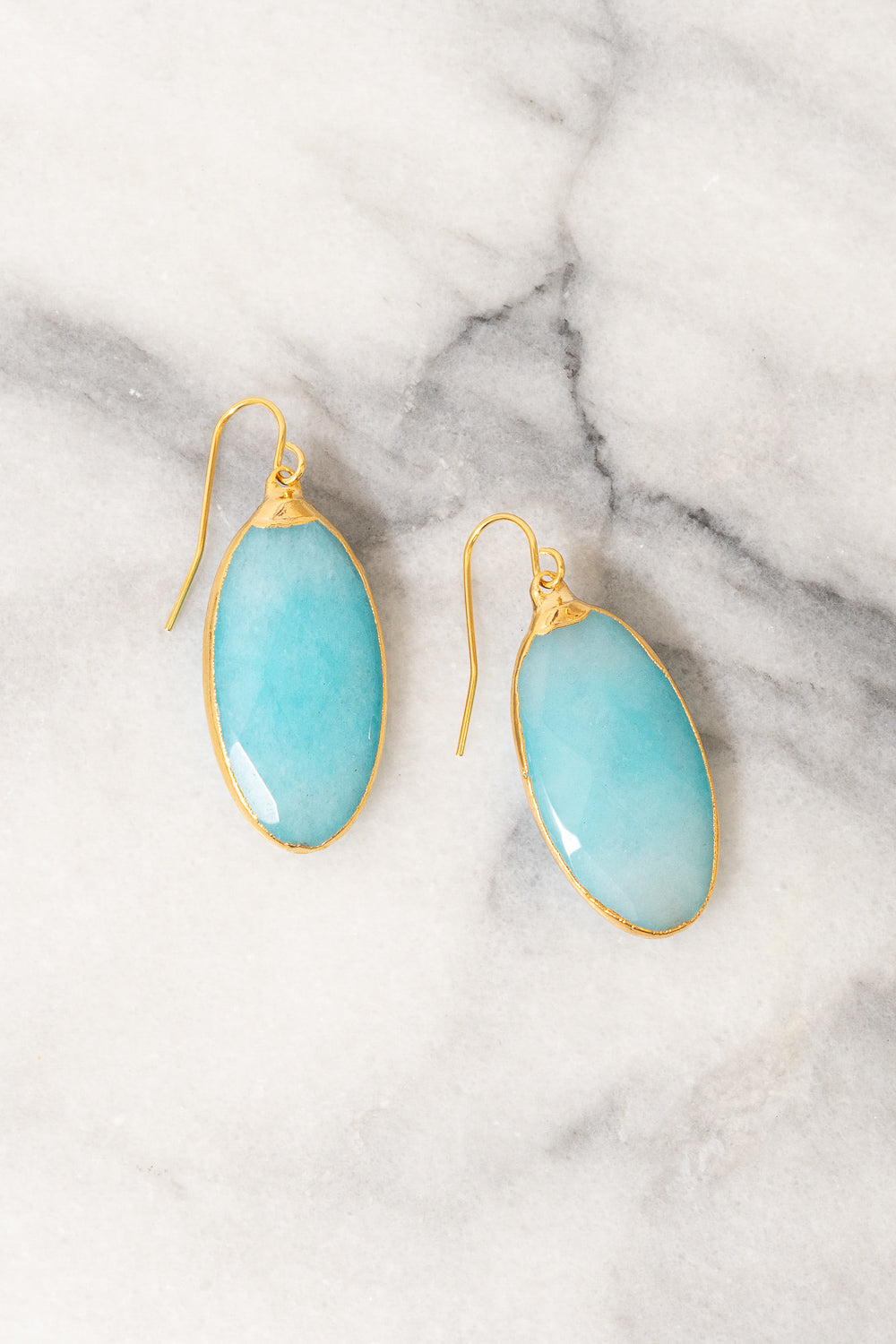 turquoise jade dangle earrings on marble