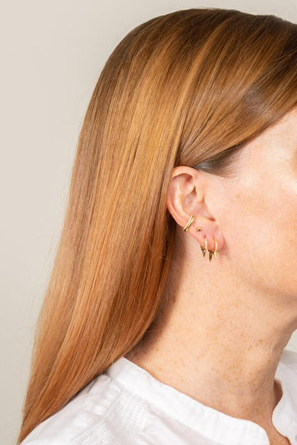 14k gold and diamond spike huggie hoop earrings on model multiple piercings