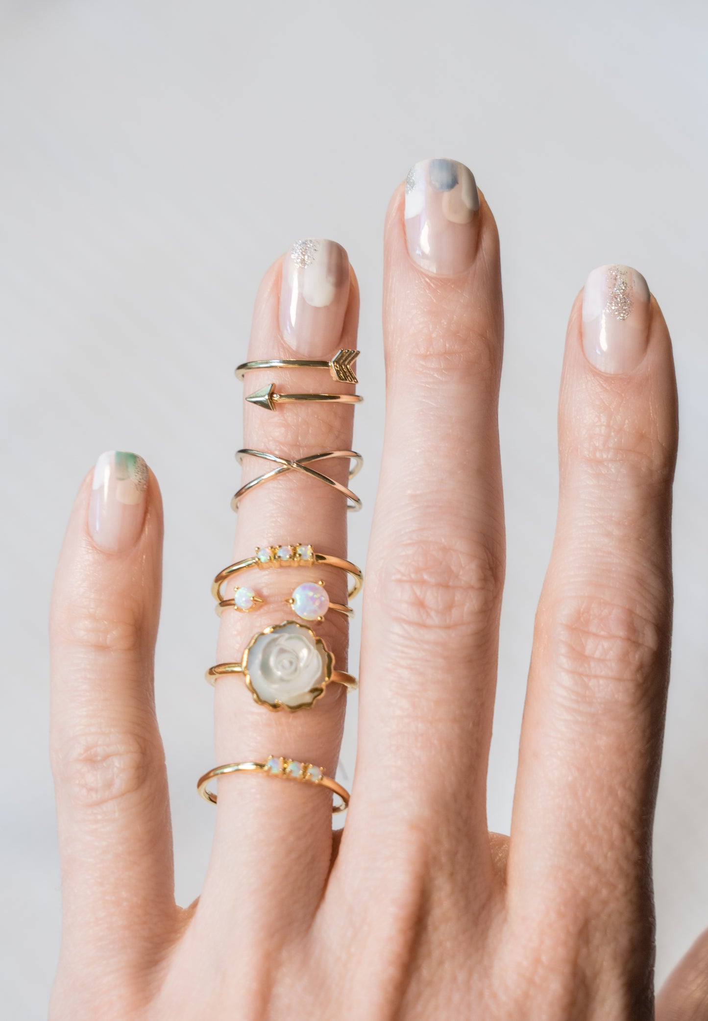 Janna Conner opal ring stacks on model hand with nail art