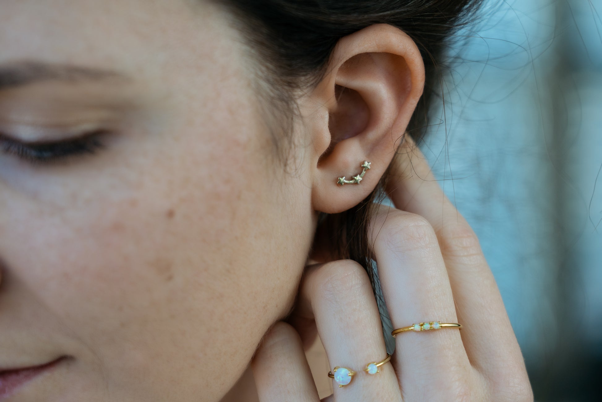 gold star ear climbers on model closeup and opal rings