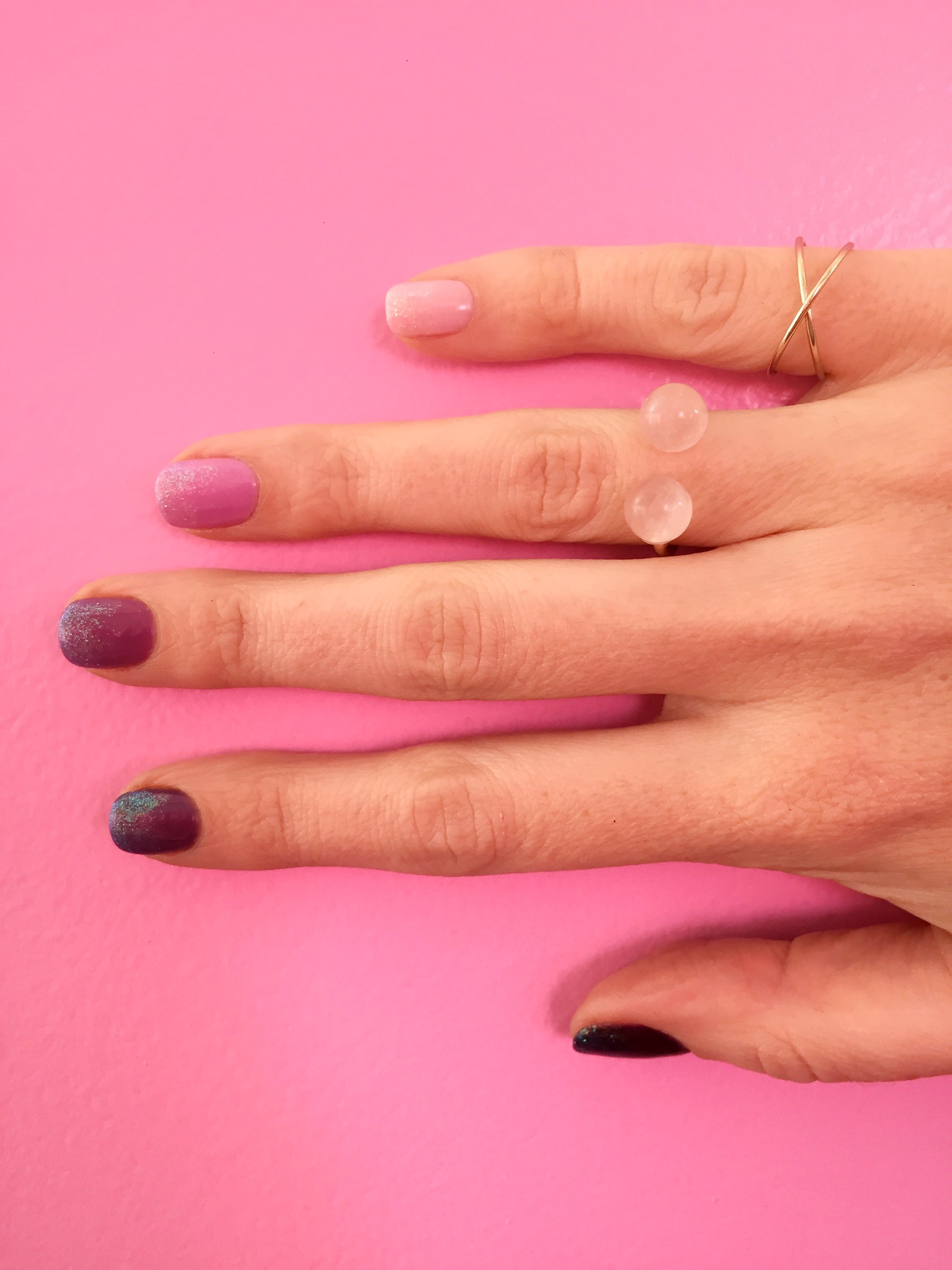 ombre glitter nails on model with rose quartz thibaut ring by janna Conner with pink wall