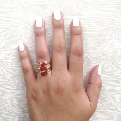 red semi precious stacking rings on hand with three stacked